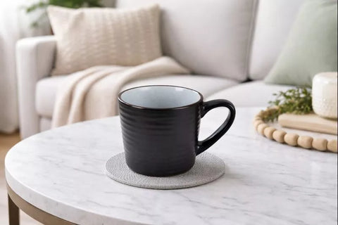 تفاصيل مج سيراميك أسود مطفي مع داخلي فاتح منقط ومقبض مريح – Close-up of matte black ceramic mug with speckled interior and handle
