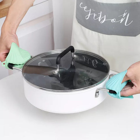 ماسك سيليكون عازل للحرارة أثناء الاستخدام مع الأواني الساخنة – Heat-resistant silicone pot holder in use with hot cookware
